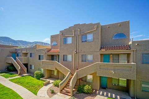 an image of an apartment building with stairs and grass